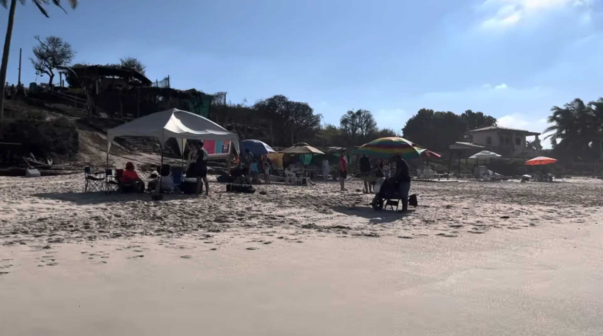 Beach tents and umbrellas along Litibú's quiet shore